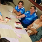 Grupo de docentes y colaboradores del colegio reunidos alrededor de una mesa celebrando un momento especial