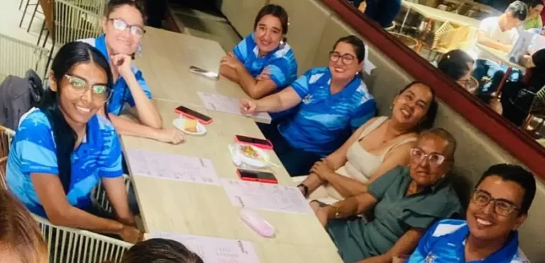 Grupo de docentes y colaboradores del colegio reunidos alrededor de una mesa celebrando un momento especial