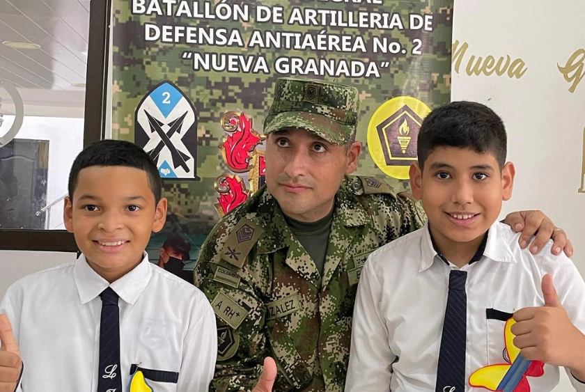 Estudiantes del Liceo Jesús de Nazareth participan en una izada de bandera junto a un miembro del Ejército Nacional